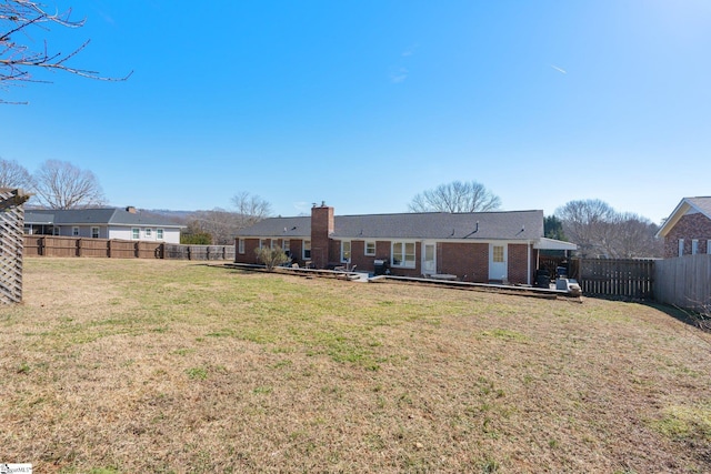 back of property with a yard and a patio