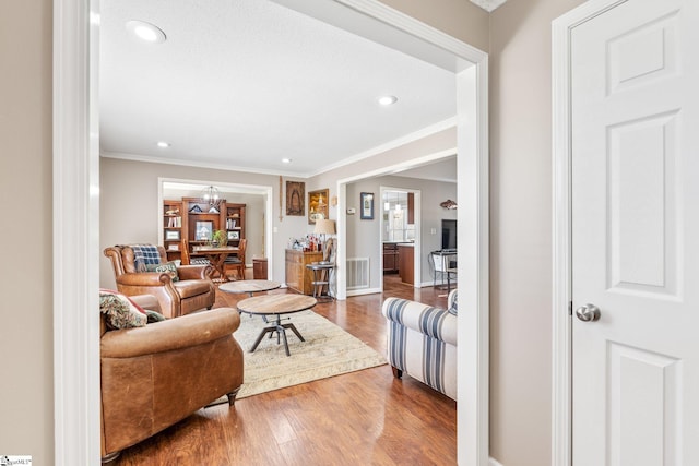 living room with hardwood / wood-style flooring and crown molding