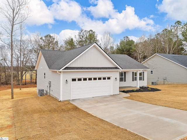 view of front of house featuring cooling unit, a garage, and a front yard