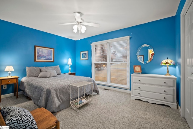 carpeted bedroom with ceiling fan and a closet