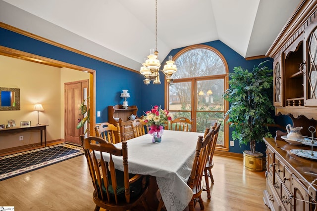 dining space featuring lofted ceiling, a chandelier, and light wood-type flooring