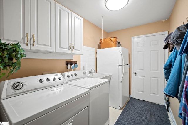 laundry area with washing machine and dryer and cabinets