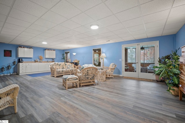 living room with a paneled ceiling, hardwood / wood-style floors, and french doors