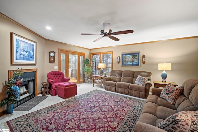 carpeted living room with crown molding, ceiling fan, and a fireplace