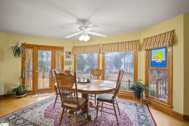 dining area with wood-type flooring and ceiling fan