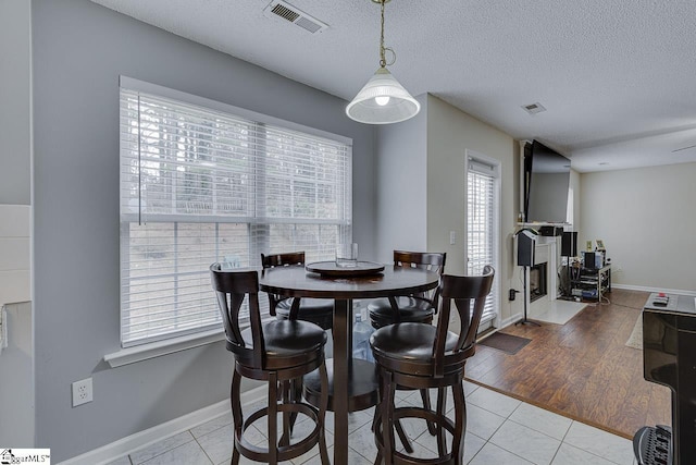 tiled dining space with a textured ceiling