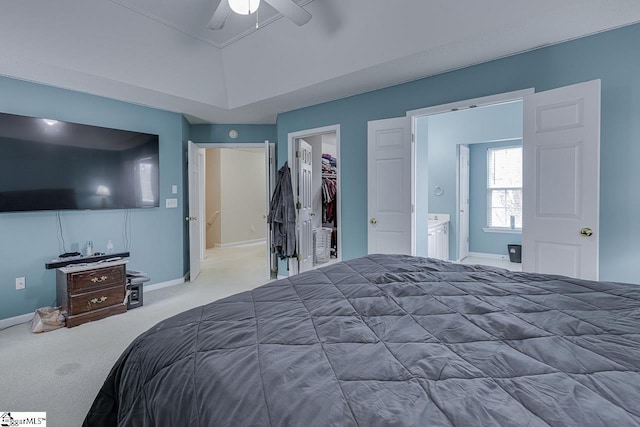 carpeted bedroom with a walk in closet, a closet, and ceiling fan