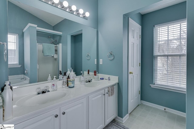 bathroom with vaulted ceiling, vanity, and a bathing tub