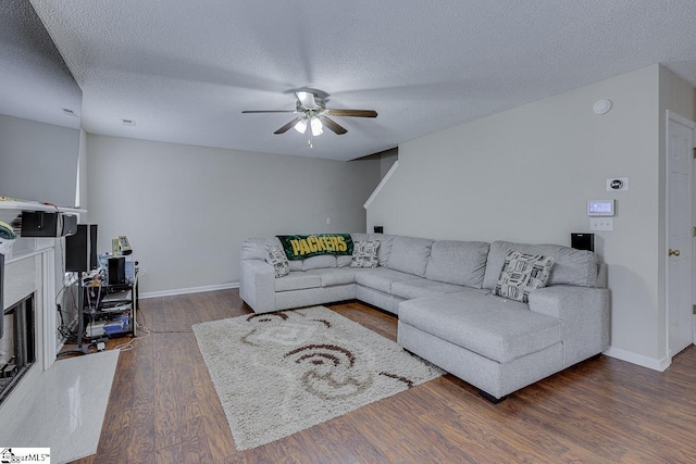 living room with a textured ceiling, dark hardwood / wood-style floors, and ceiling fan