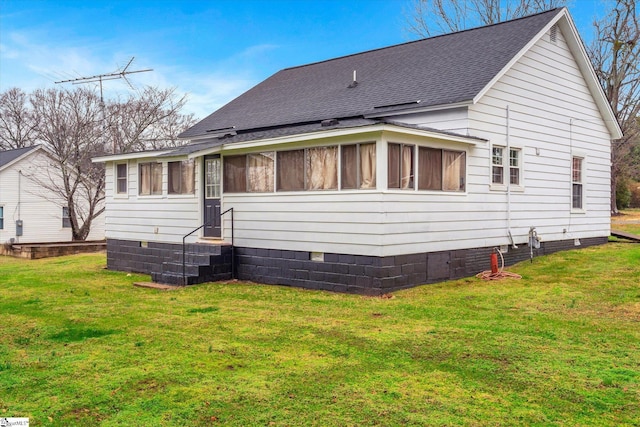 rear view of house with a sunroom and a lawn