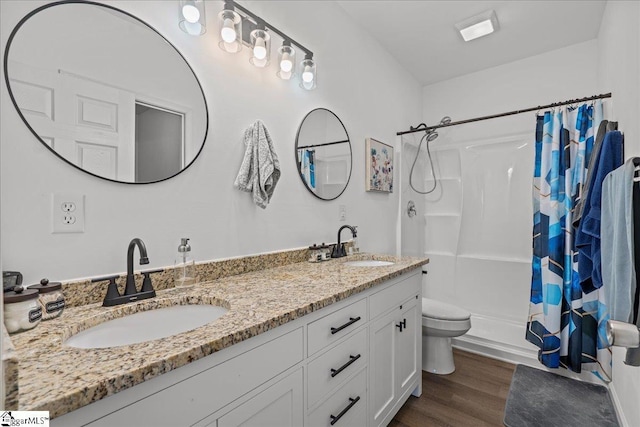 bathroom featuring hardwood / wood-style flooring, vanity, toilet, and curtained shower