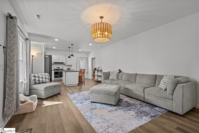 living room featuring an inviting chandelier and light hardwood / wood-style floors