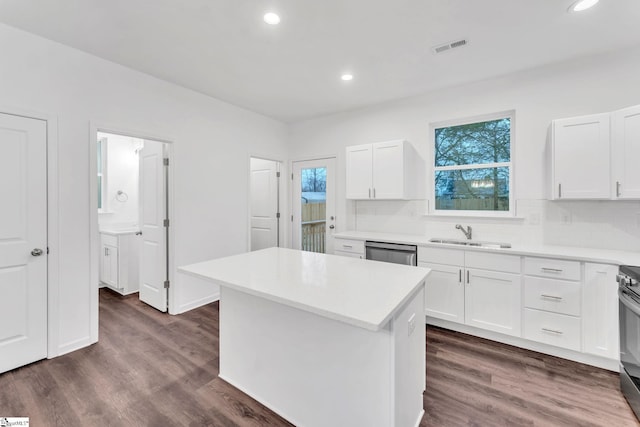 kitchen with a kitchen island, dark hardwood / wood-style floors, sink, white cabinets, and stainless steel appliances