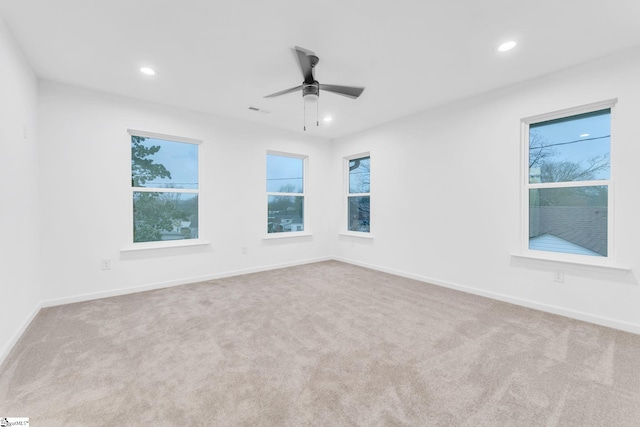 spare room with light colored carpet and ceiling fan