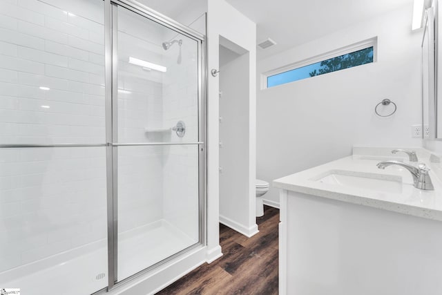 bathroom featuring vanity, hardwood / wood-style floors, an enclosed shower, and toilet