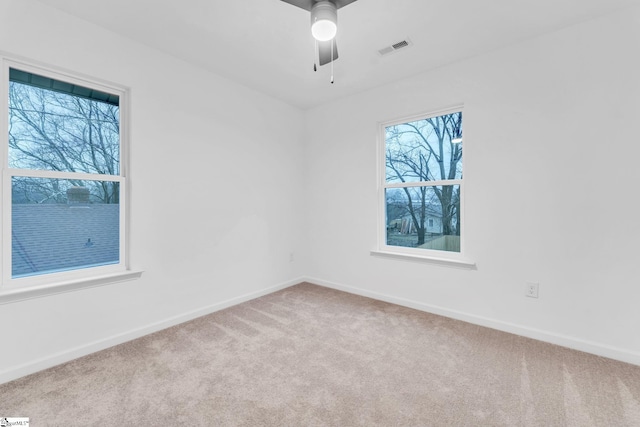 carpeted spare room with ceiling fan