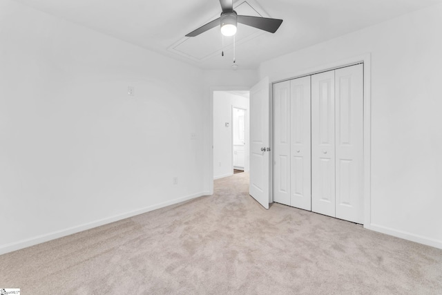 unfurnished bedroom with light colored carpet, ceiling fan, and a closet