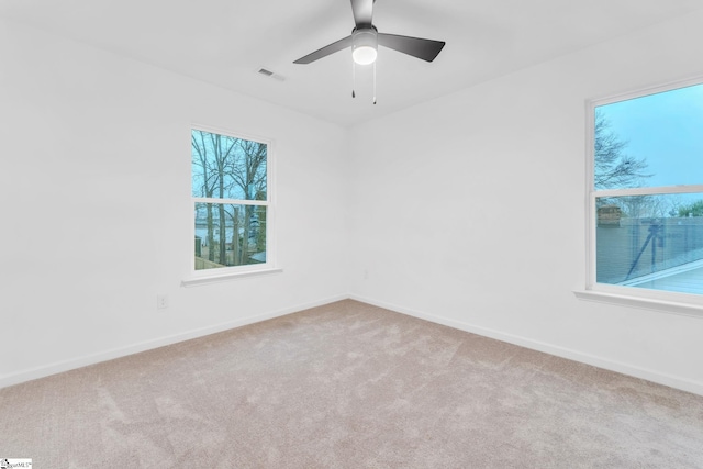 carpeted spare room with ceiling fan