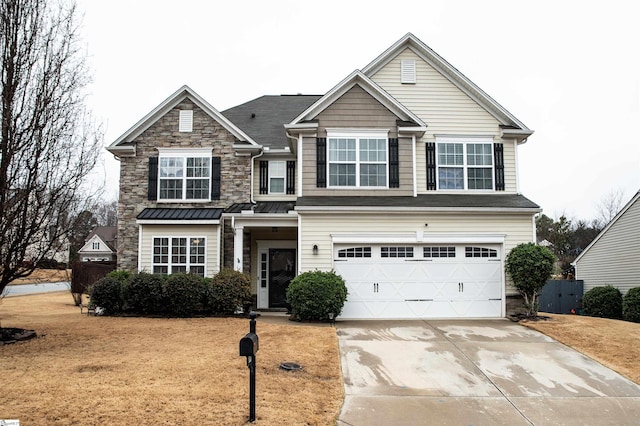 traditional-style home with a standing seam roof, stone siding, fence, concrete driveway, and an attached garage