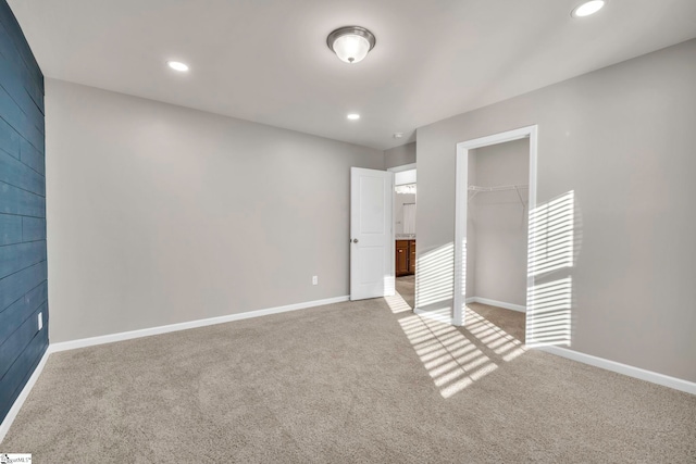 unfurnished bedroom featuring light colored carpet and a closet