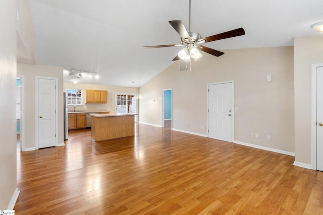 unfurnished living room featuring ceiling fan, high vaulted ceiling, sink, and light hardwood / wood-style floors