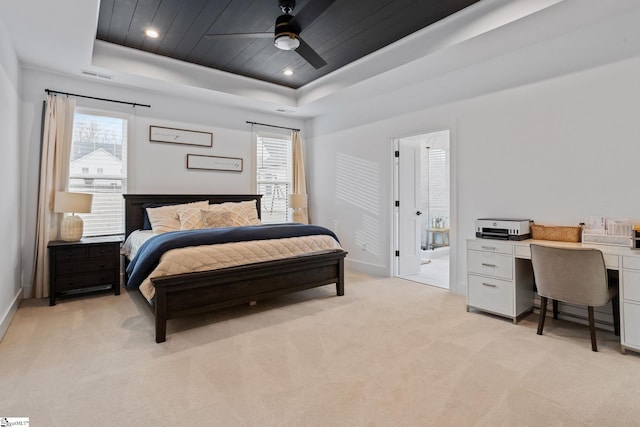 bedroom with ceiling fan, light carpet, wood ceiling, and a tray ceiling