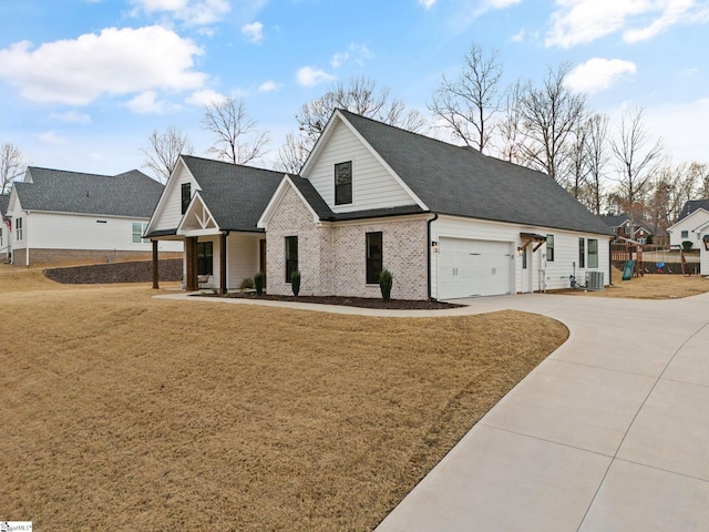 view of front of house with central AC, a garage, and a front lawn