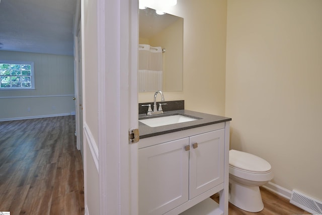 bathroom with vanity, hardwood / wood-style floors, and toilet