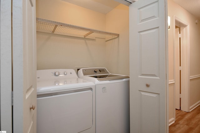 washroom featuring light hardwood / wood-style floors and washing machine and clothes dryer