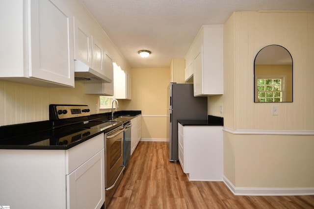 kitchen featuring sink, a textured ceiling, light hardwood / wood-style flooring, appliances with stainless steel finishes, and white cabinets