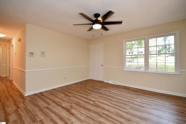 unfurnished room with ceiling fan, a textured ceiling, and light hardwood / wood-style flooring