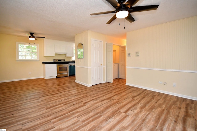 kitchen with stainless steel electric range, light hardwood / wood-style flooring, a textured ceiling, and white cabinets