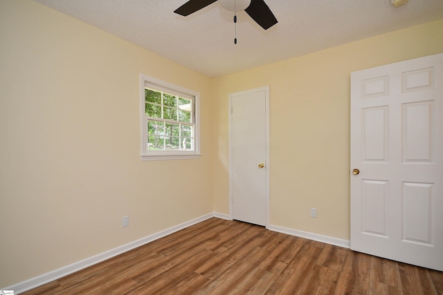 unfurnished bedroom with ceiling fan, hardwood / wood-style floors, and a textured ceiling