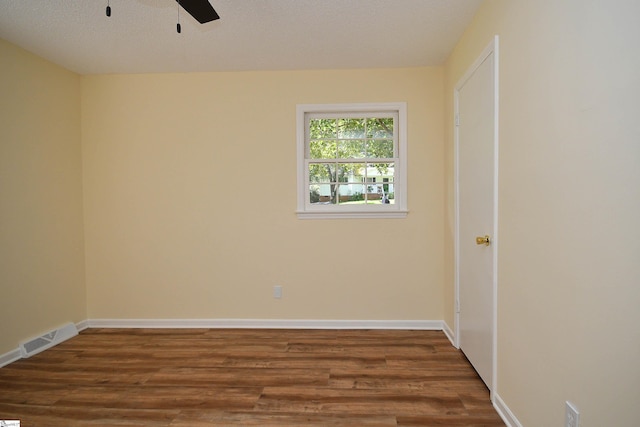 spare room featuring ceiling fan and dark hardwood / wood-style flooring