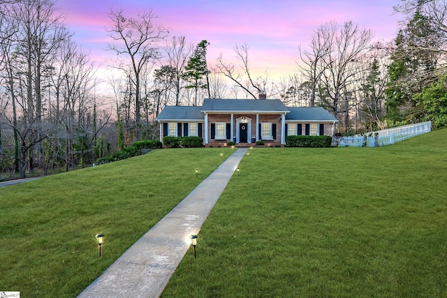 single story home featuring a lawn and covered porch