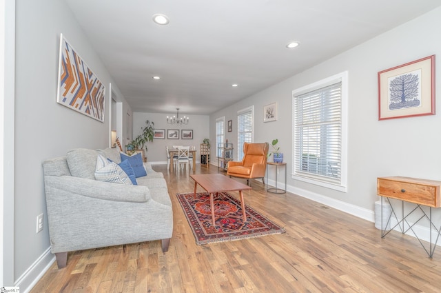 living room with light hardwood / wood-style flooring and a chandelier