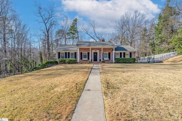 single story home featuring covered porch and a front yard