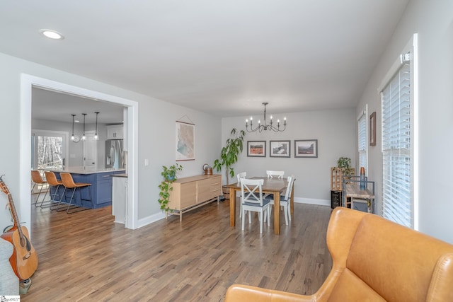 dining area featuring light hardwood / wood-style flooring and a notable chandelier