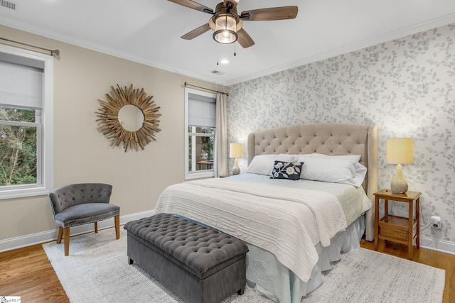 bedroom with ceiling fan, ornamental molding, and wood-type flooring