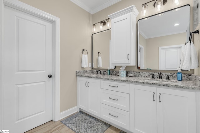 bathroom with hardwood / wood-style flooring, ornamental molding, and vanity