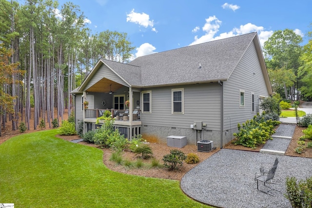 rear view of house featuring a deck, ceiling fan, and a lawn