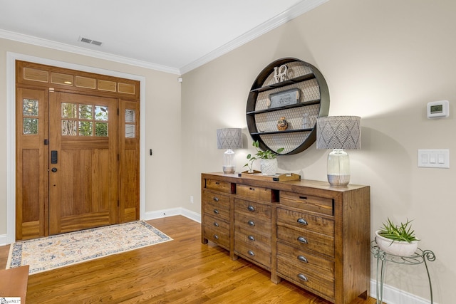 entryway with ornamental molding and light wood-type flooring