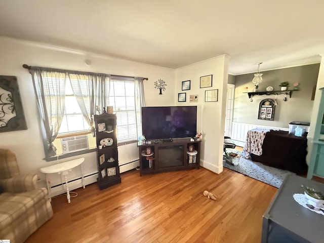 living room featuring cooling unit, hardwood / wood-style flooring, and baseboard heating