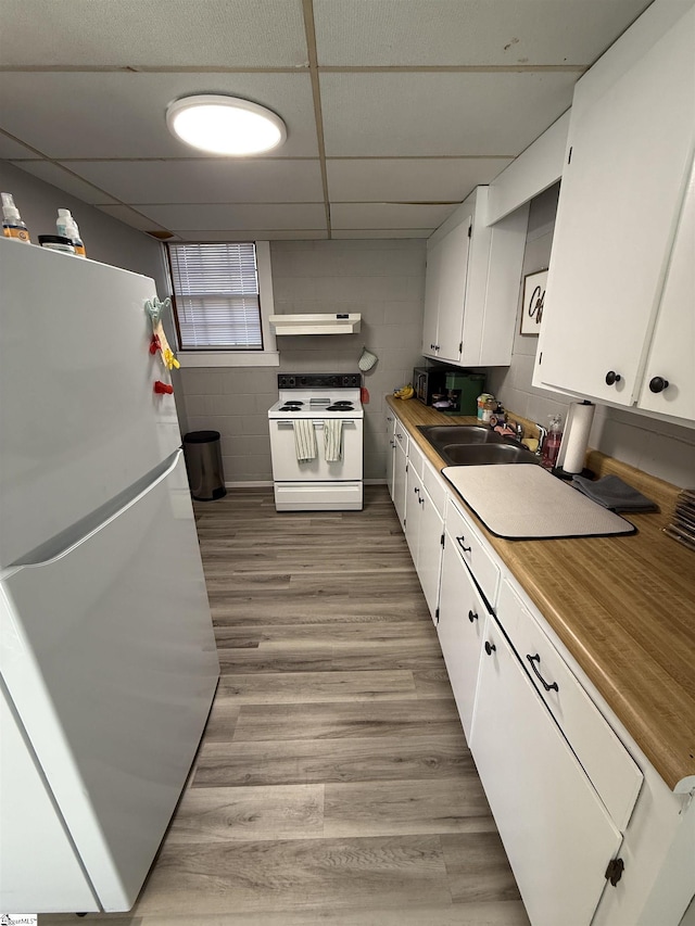 kitchen featuring sink, a paneled ceiling, white appliances, light hardwood / wood-style floors, and white cabinets