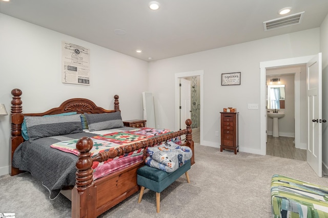 bedroom with sink and light carpet