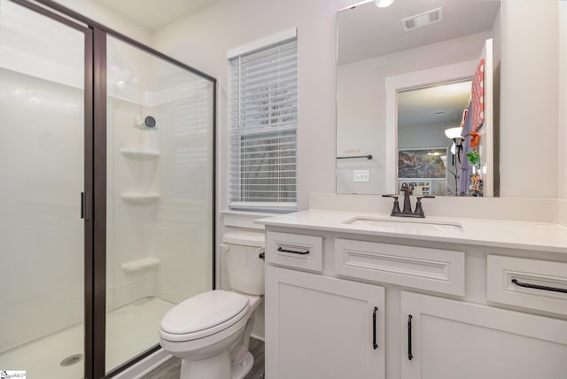 bathroom featuring walk in shower, vanity, and toilet