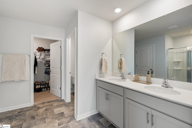 bathroom with vanity, toilet, and an enclosed shower