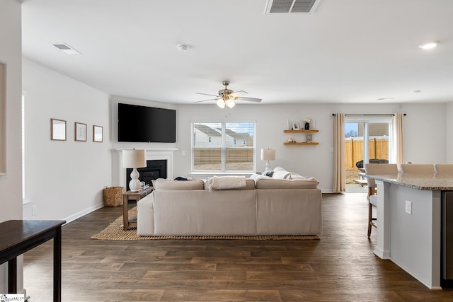 living room with ceiling fan and dark hardwood / wood-style flooring