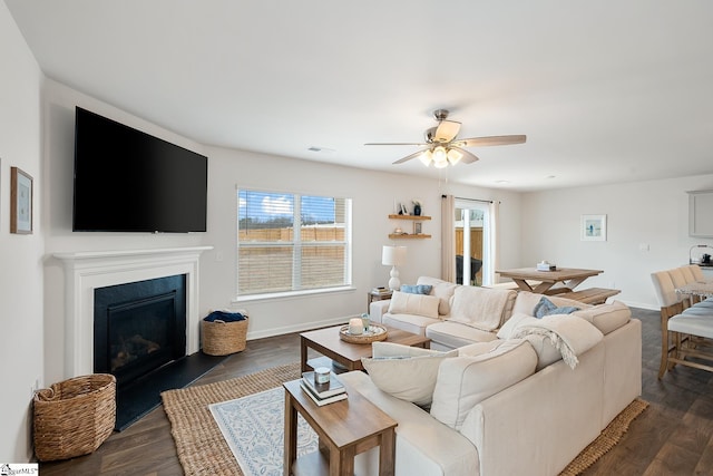 living room with dark wood-type flooring and ceiling fan