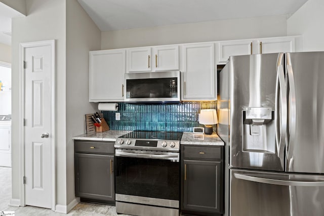 kitchen featuring white cabinetry, decorative backsplash, stainless steel appliances, and light stone counters